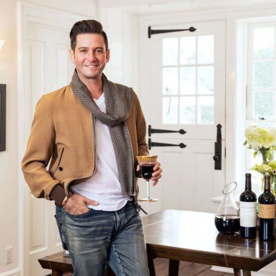 Josh Flagg with a glass of red wine in hand